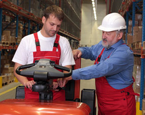 older man teaching forklifting